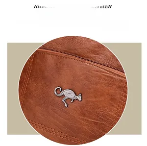 Détail du cuir marron à motif litchi avec logo kangourou argenté et coutures précises