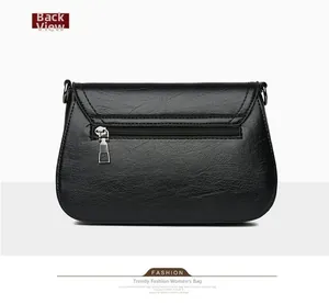 Back view of black leather shoulder bag with functional zipper pocket and dark hardware