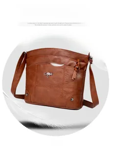 Détail du sac à bandoulière en similicuir marron doux avec surpiqûres et logo kangourou