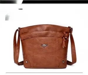 Vue de face du sac bandoulière vintage en cuir PU marron avec logo kangourou et pompon