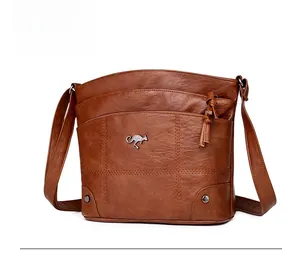 Vue détaillée du sac bandoulière marron en cuir souple avec coutures et poches zippées