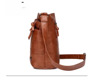 Vue latérale du sac seau rétro en similicuir marron avec fermeture à glissière à glands