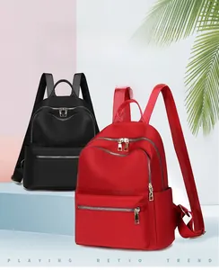Détail du sac à dos en tissu Oxford rouge et noir avec plusieurs poches zippées pratiques