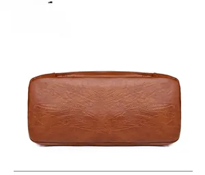 Détail du fond du sac en cuir marron montrant les coutures et la texture souple