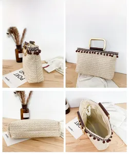 Detail view of woven straw tote bag featuring tassel charms and metallic handles