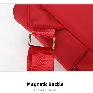 Vue détaillée de la boucle en métal doré sur un sac à dos rouge en tissu Oxford