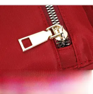 Détail macro d'une fermeture éclair dorée de qualité sur sac à dos en tissu Oxford rouge