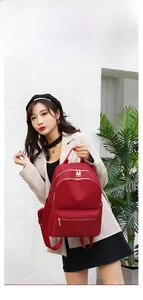 Détail d'un sac à dos rouge en tissu oxford avec double fermeture éclair et poches