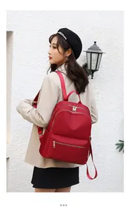 Détail d'un sac à dos rouge en nylon résistant à l'eau avec fermetures éclair en métal doré