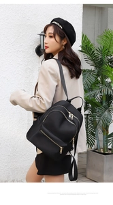 Vue latérale du sac à dos en tissu Oxford noir avec plusieurs poches zippées porté