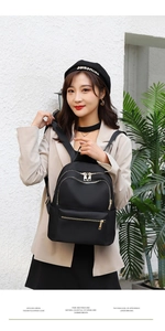 Détail d'un sac à dos noir en tissu Oxford avec fermetures éclair dorées en style urbain