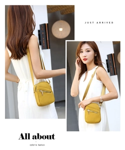 Detailed views of yellow nylon crossbody bag with dual zipper compartments and wide strap