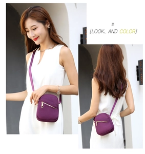 Detail view of deep purple nylon crossbody bag with metal zipper and adjustable strap