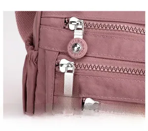 Detailed macro view of the silver metal zipper with pink rubber pullers on nylon bag