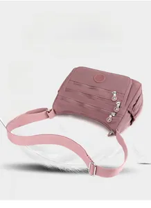 Lightweight pink nylon crossbody bag weighing only 340g shown with white feathers