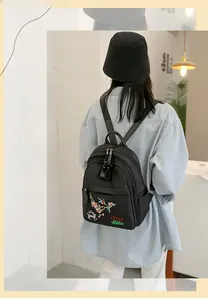Détail de broderie florale et cerf sur un sac à dos noir léger et imperméable