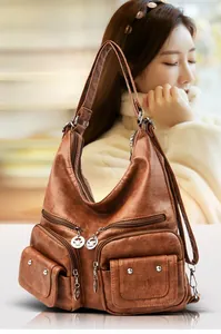 Close-up of brown vintage PU leather shoulder bag featuring multiple functional zipper pockets