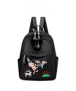 Détail frontal du sac à dos noir étanche avec broderie colorée de cerf et de fleurs