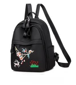 Détail de broderie florale élégante avec motif de cerf sur un sac à dos en nylon noir étanche