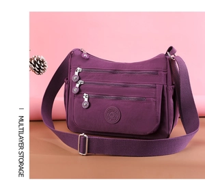 Detail of purple nylon crossbody bag featuring multi-layer zipper pockets for storage