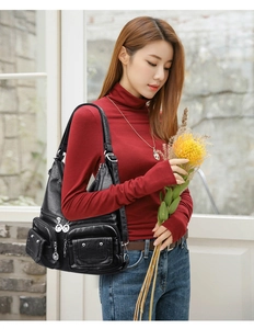 Detail view of a black soft leather backpack with multi-layer zipper pockets for women