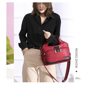 Detail of red water-resistant nylon handbag with double zippers and metal pullers