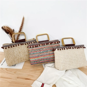 Handmade straw tote bags in various colors with metal handles for beach vacation style