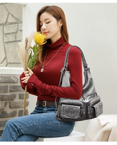 Detail view of the soft smoky gray PU leather texture and functional metal zipper pockets