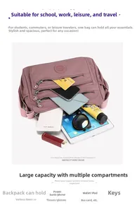 Detail view of purple nylon crossbody bag interior capacity with multiple zip compartments