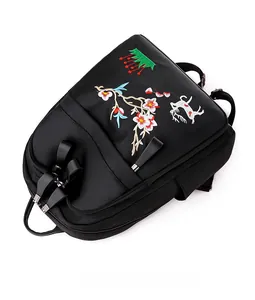 Détail de la broderie de fleurs et de cerf sur un sac à dos en nylon noir
