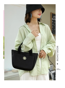 Photo lifestyle d'une femme avec un cabas noir en nylon assorti à une tenue décontractée