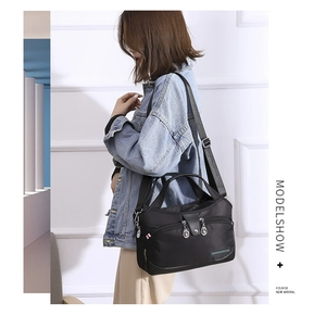 Detail shot of the black water-resistant nylon bag with dual handles and fashion label