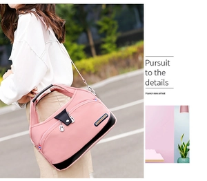 Detail of pink waterproof nylon bag showing zip compartments and adjustable shoulder strap