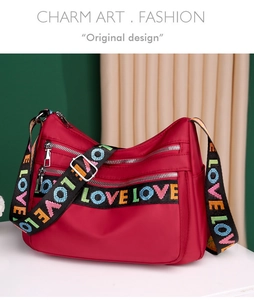 Detail of red nylon crossbody bag featuring multi-zipper pockets and colorful LOVE strap