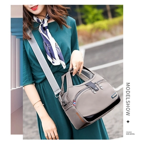 Detailed view of grey waterproof oxford fabric handbag with multi-pocket and wide shoulder strap