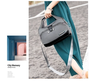 Detailed view of the water-resistant oxford fabric texture and silver zippers on grey bag