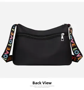 Detail of black nylon crescent crossbody bag with hidden back zipper and silver metal hardware