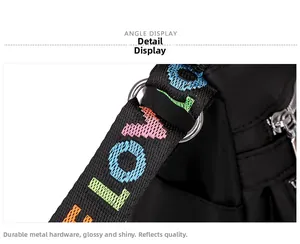 Detail of black nylon crossbody bag featuring colorful LOVE letter strap and silver metal hardware