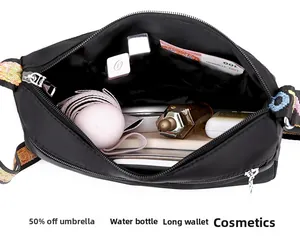 Interior view of black nylon crossbody bag showing large storage capacity for daily essentials