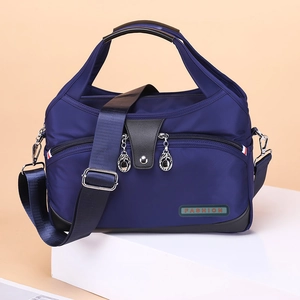 Waterproof navy blue oxford nylon tote bag with leather trim and multiple compartments