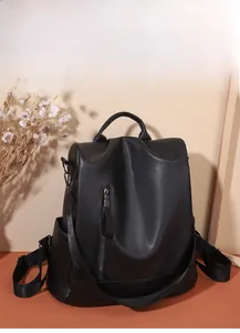 Close-up of black PU leather backpack showing lychee texture and front vertical zipper