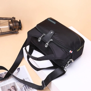 Waterproof black nylon tote bag with adjustable strap shown from a 45-degree angle view