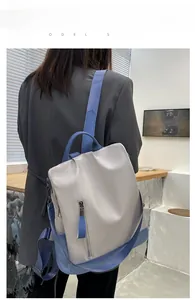 Model wearing a minimalist two-tone PU leather backpack with anti-theft zipper detail