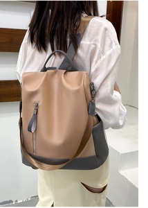 Close-up of khaki and gray backpack with vertical zipper pocket and wide straps