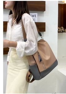 Side view of two-tone PU leather backpack with vertical zipper pocket on a model