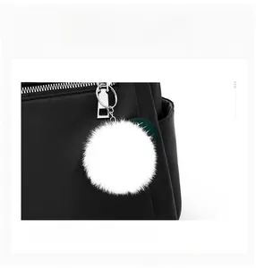 Vue détaillée d'un sac à dos oxford noir avec fermeture éclair argentée et pendentif