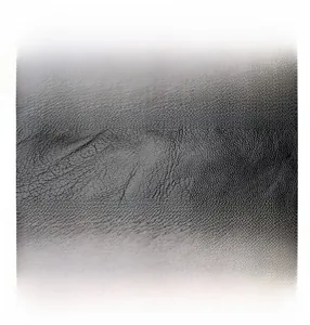 Close-up of high-quality black faux leather with detailed litchi grain texture for handbag