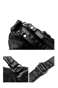 Detailed macro view of black lychee grain texture and reinforced metal zippers on the bag