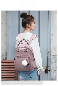 Sac à dos Oxford rose pour femme avec breloque en fausse fourrure sur un mannequin