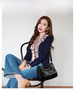Lifestyle view of a black multi-zippered PU leather crossbody bag worn by a model